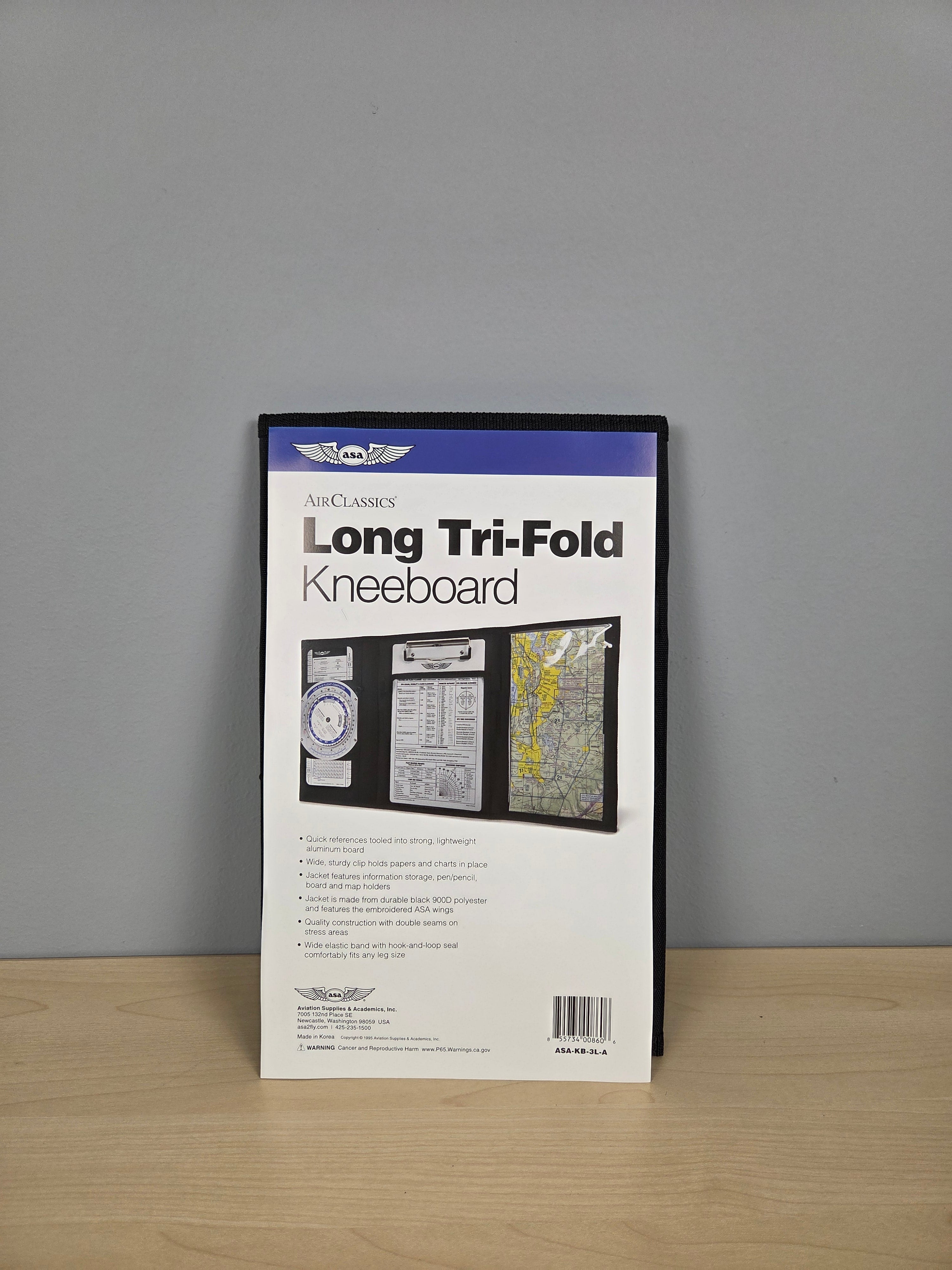 ASA Air Classics Long Tri-Fold Kneeboard package standing upright on a light wood surface against a gray wall.