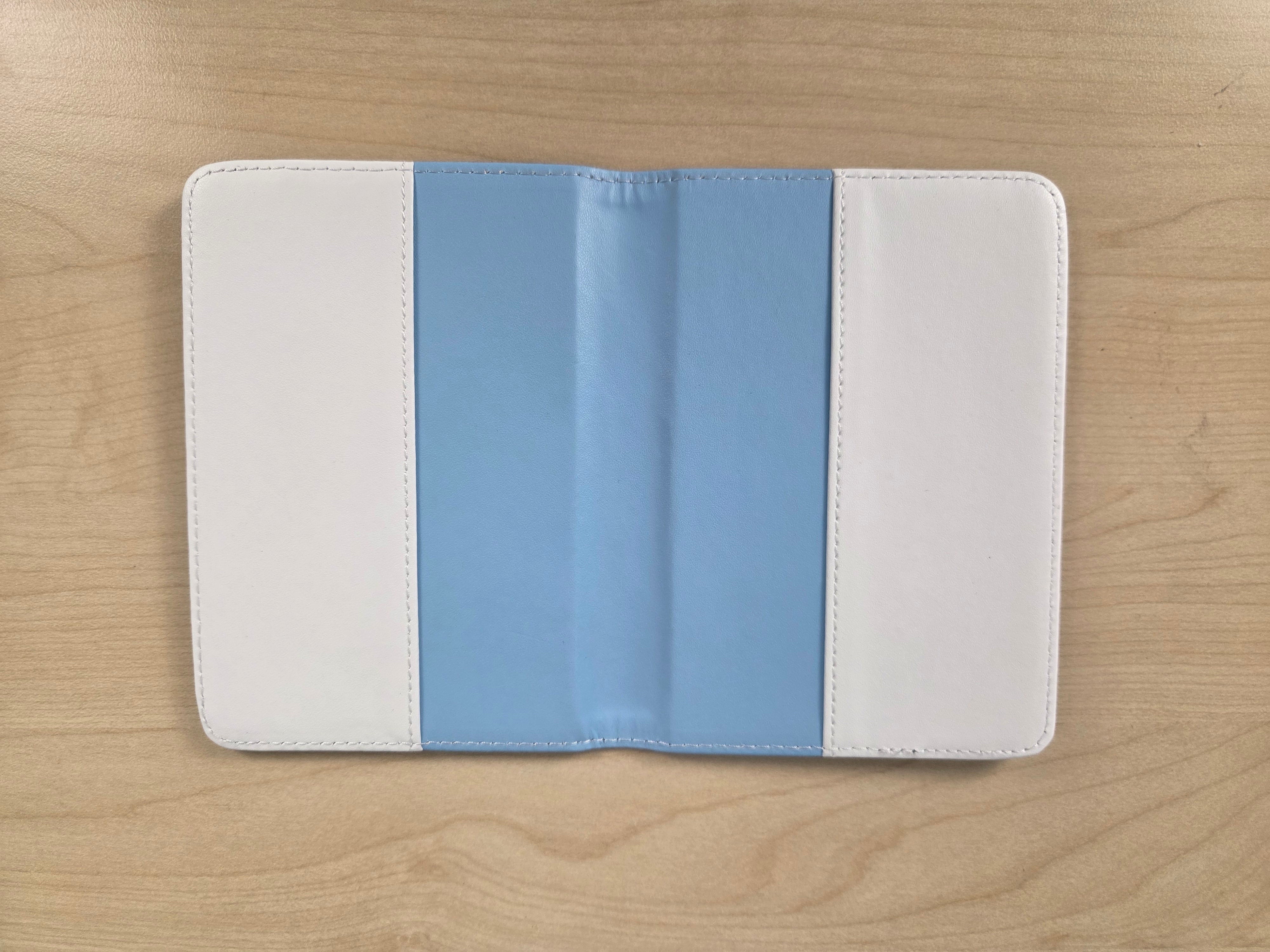 A tablet sleeve with a vertical color-blocked design of white, light blue, and white, shown open on a light wood grain surface.