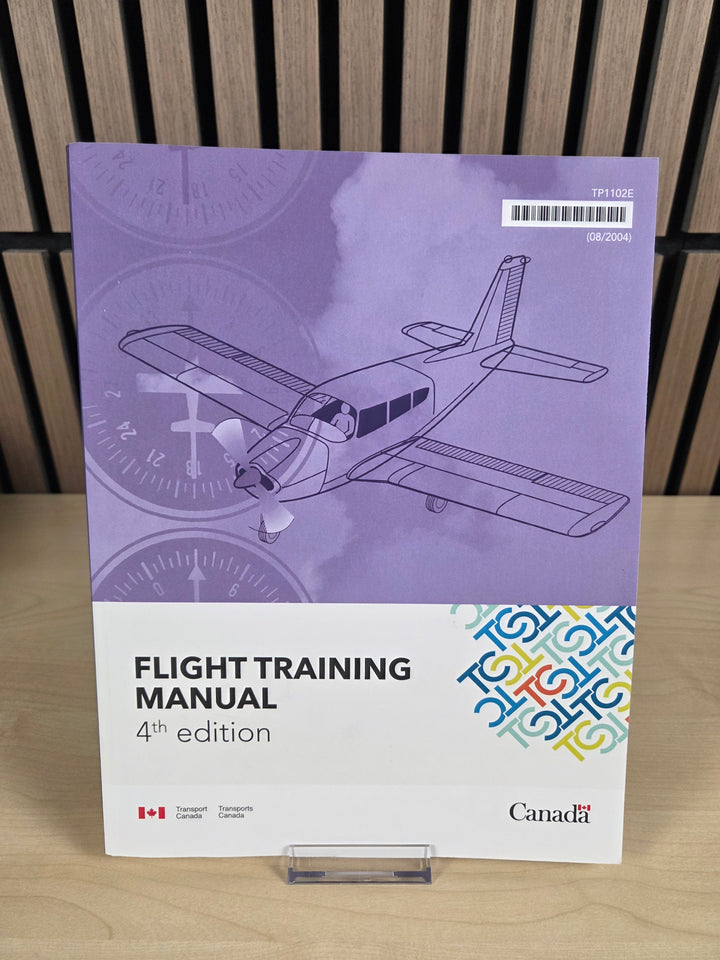 A book named "Flight training manual" sitting on wooden surface.