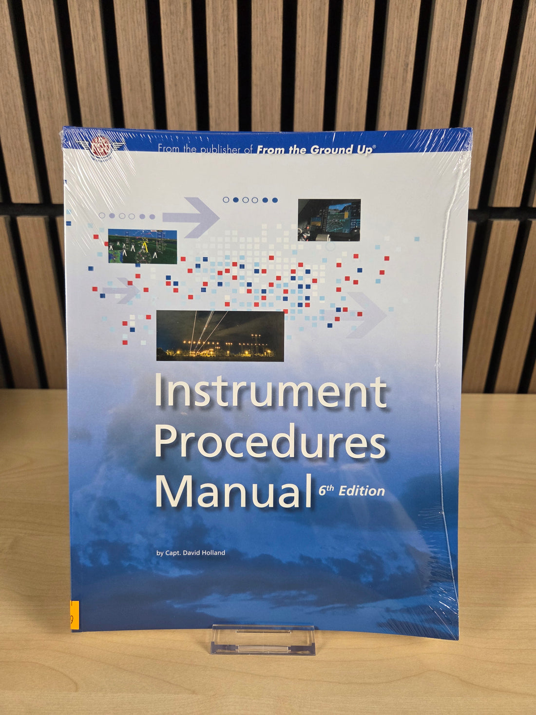 a book named "Instrument procedures manual" sitting on wooden surface. 