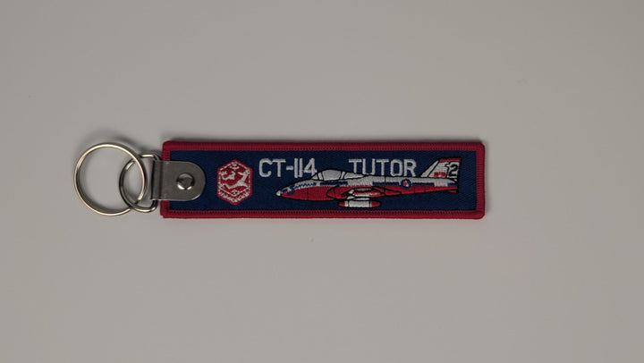 A rectangular fabric keychain featuring a red and navy blue fire department design with a white jet graphic and the text 'CT-14 JETTOR', attached to a silver metal split ring on a neutral gray background.