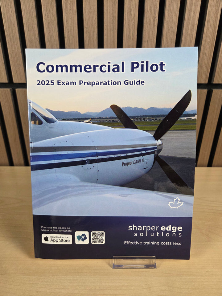 Book titled 'Commercial Pilot 2025 Exam Preparation Guide' by Sharperedge Solutions on a wooden surface.