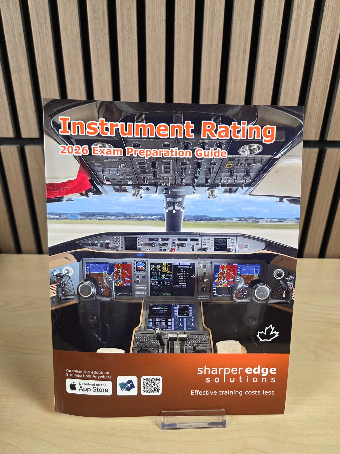 Book titled 'Instrument Rating 2023 Exam Preparation Guide' on a wooden surface