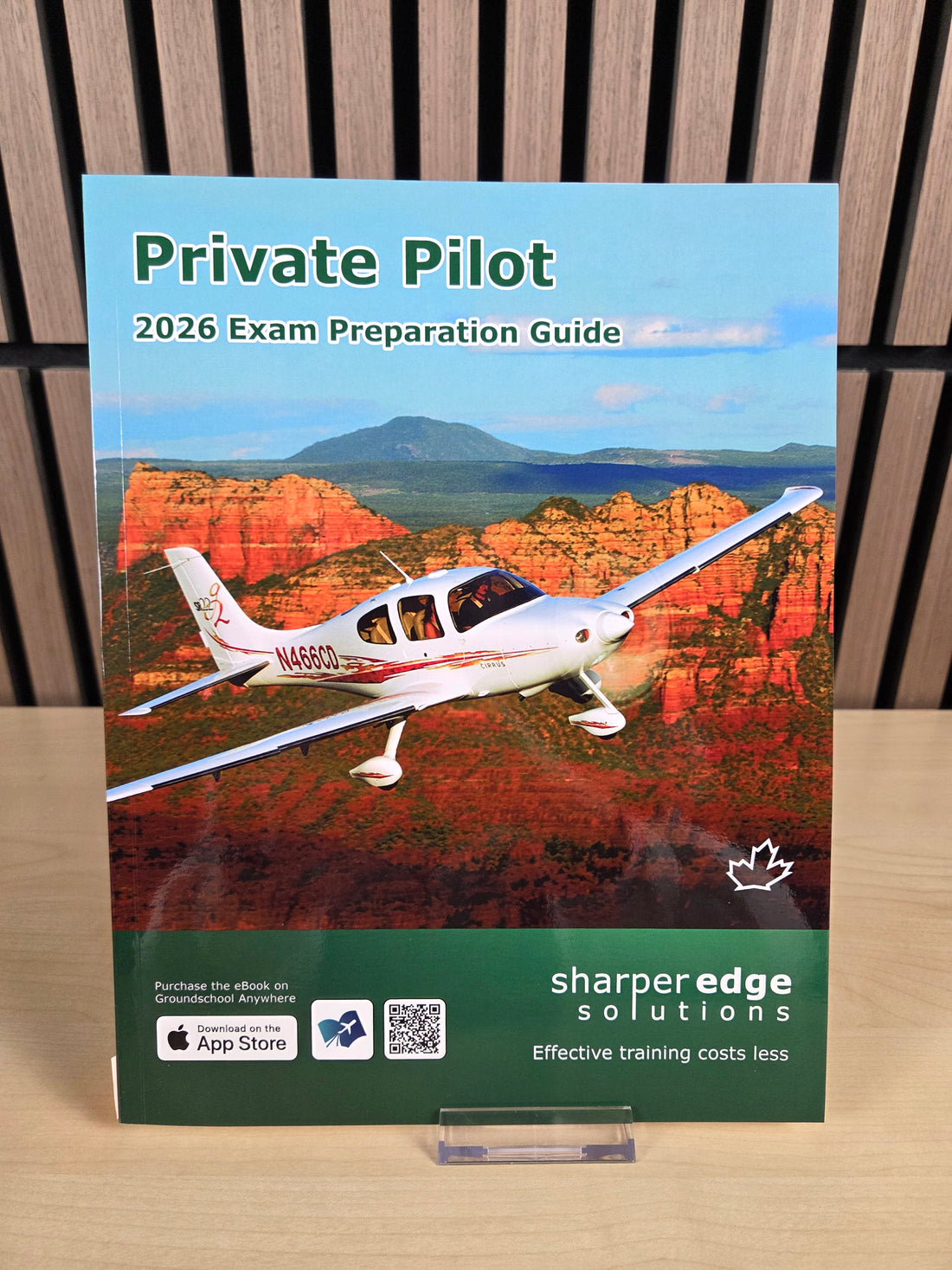Book titled 'Private Pilot 2026 Exam Preparation Guide' by Sharperedge Solutions on a wooden surface.