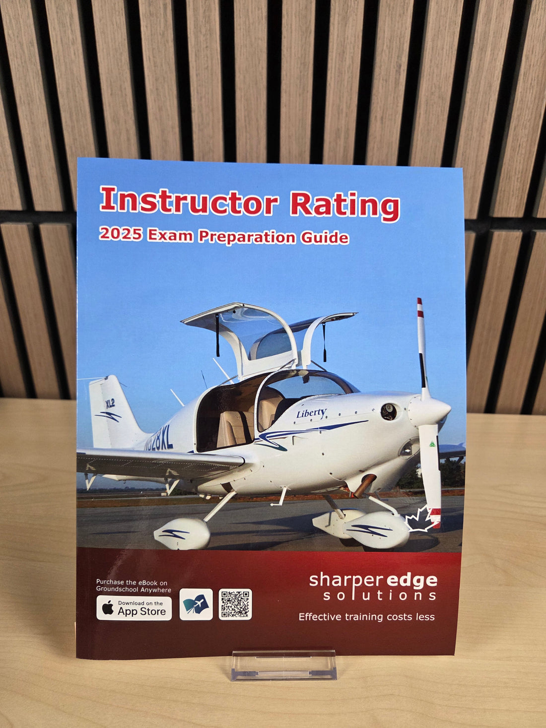 Book titled 'Instructor Rating 2025 Exam Preparation Guide' with an airplane on the cover, placed on a wooden surface.
