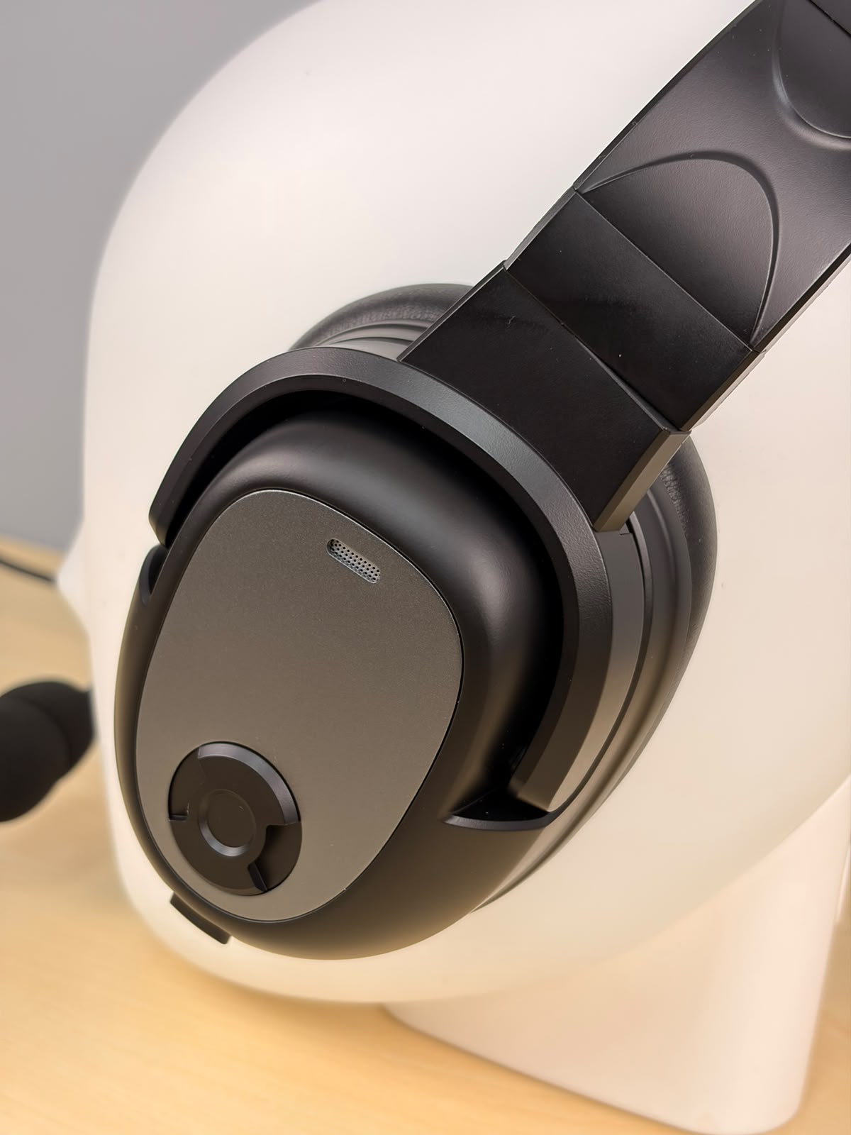 Close up of Raytalk ph700A headset sitting on a fake head and on a wooden desk with gray background 