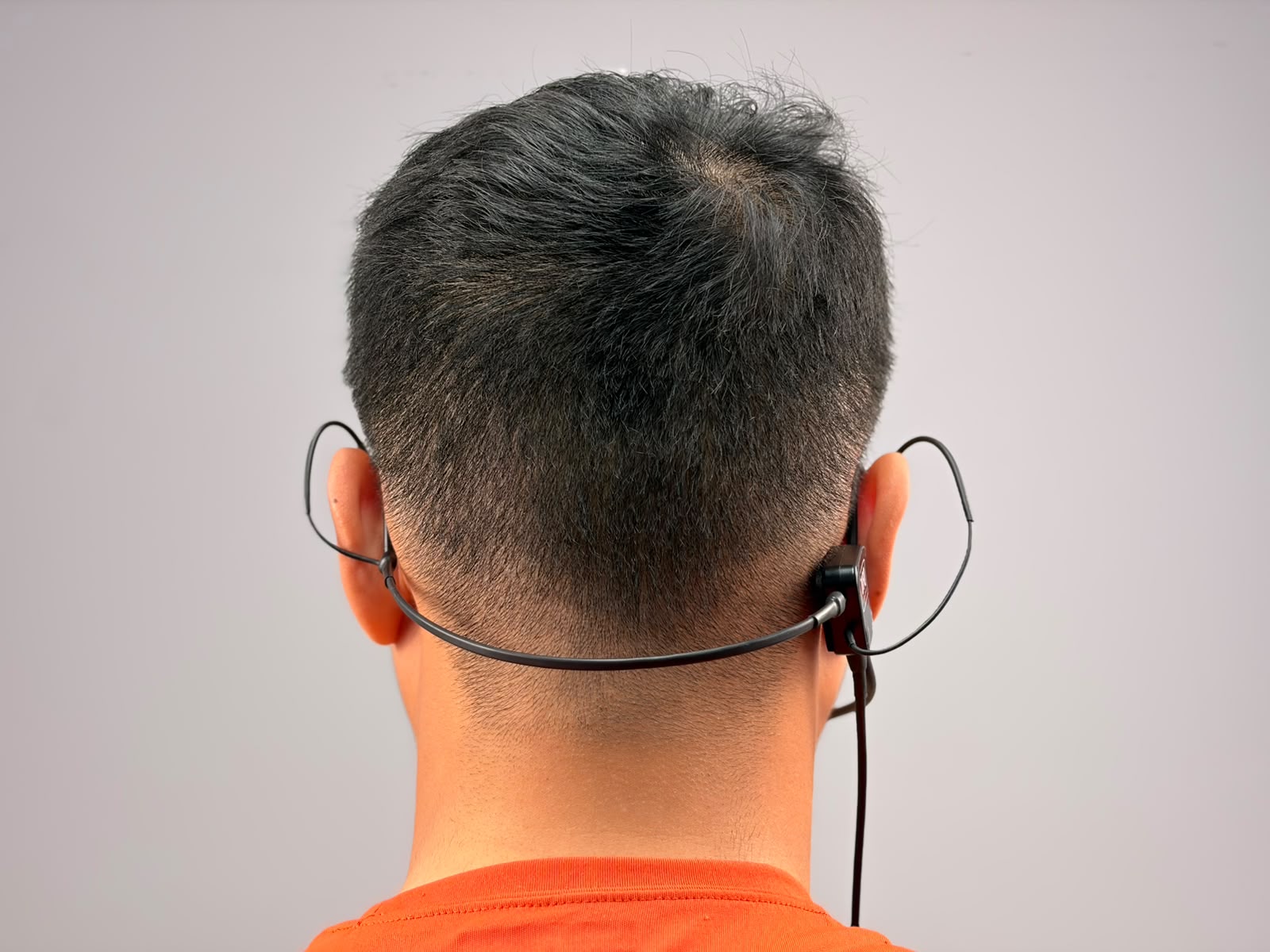 A person wearing UFQ L2 aviation headset, picture taken from behind