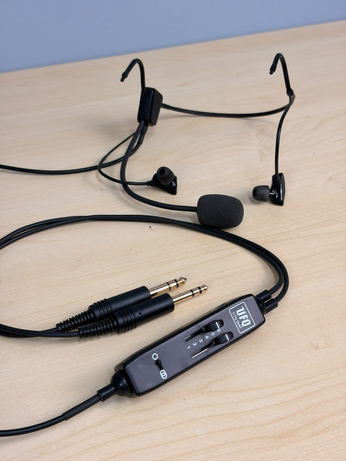  UFQ L2 aviation headset sitting on a wooden desk 