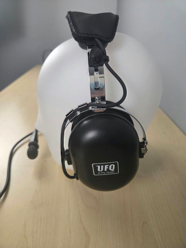 Side view of UFQ P1 headset sitting on a wooden desk with gray background