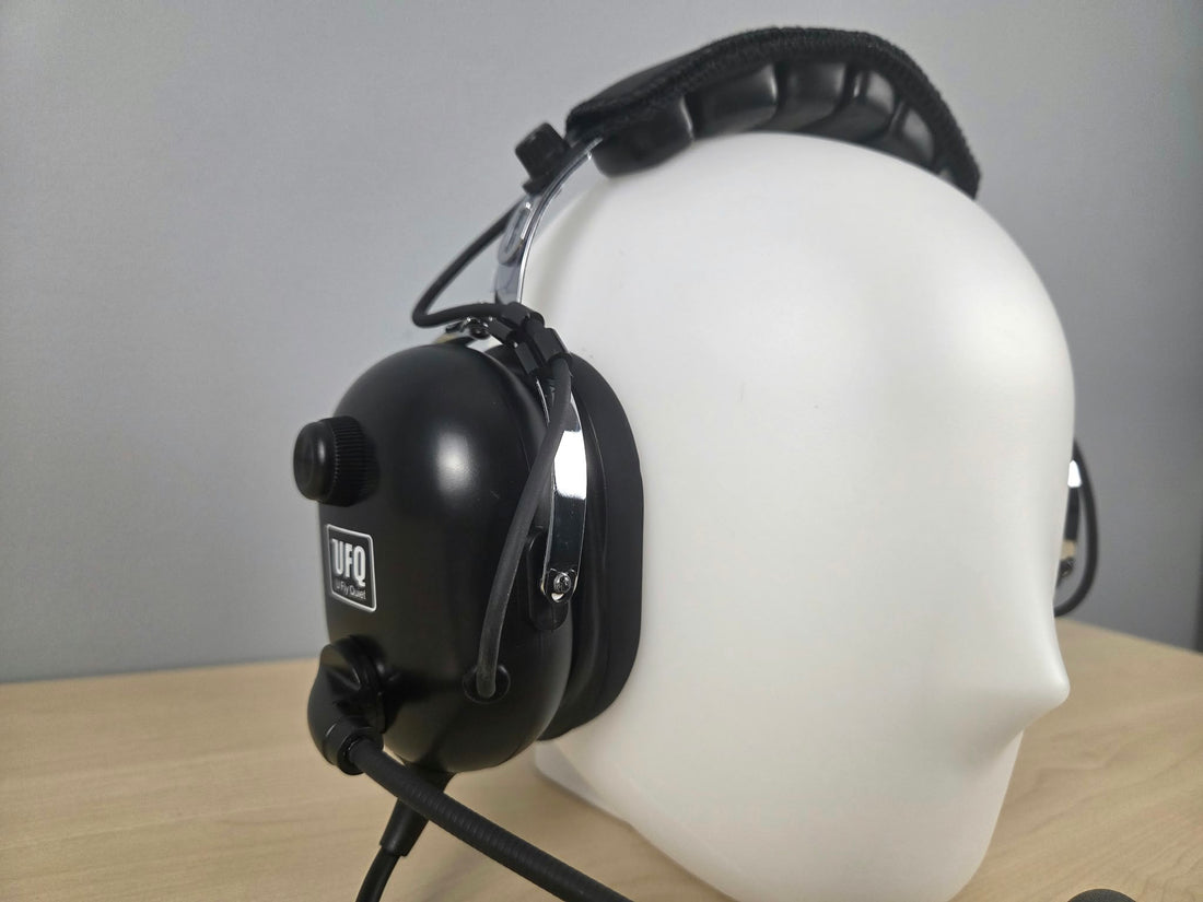 Close up of UFQ P1 headset sitting on a wooden desk with gray background