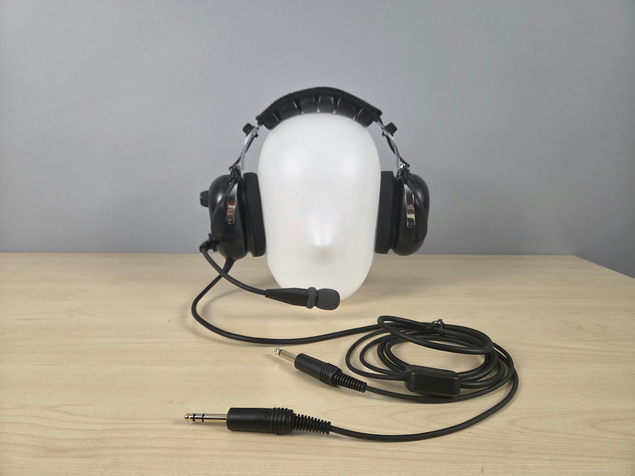 UFQ P1 headset sitting on a wooden desk with gray background